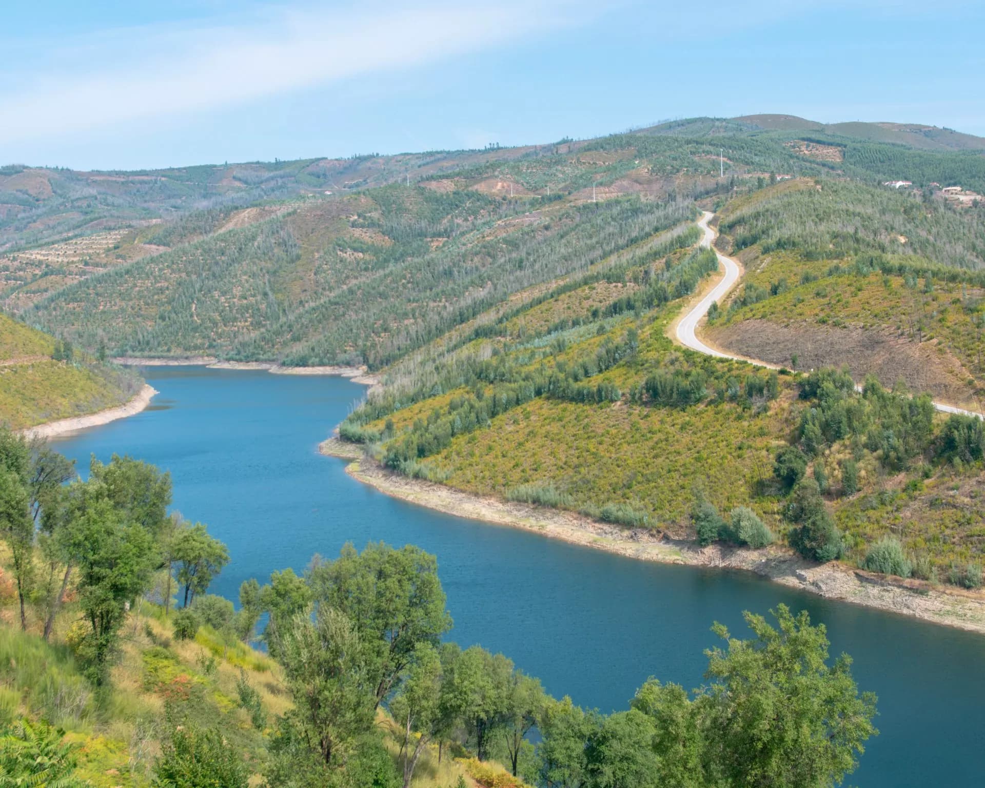 Vale com albufeira entre serras de pinhal e eucaliptal, no interior de Portugal